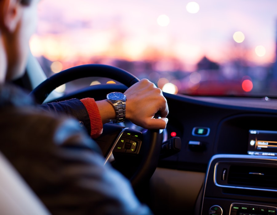 Driver behind the wheel at sunset, confidently on the road after comparing auto insurance options